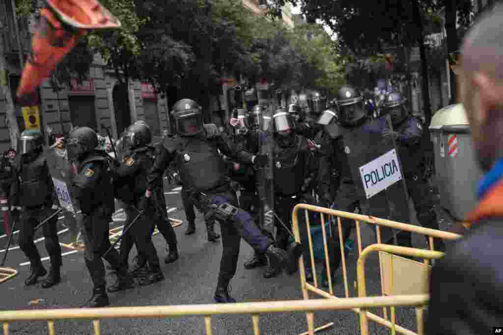 Spanish riot police removes fences as they prevent people from reaching a school assigned to be a polling station by the Catalan government in Barcelona, Oct. 1, 2017.