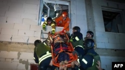 This handout photograph taken and released by the Ukrainian Emergency Service on Oct. 11, 2024, shows rescuers evacuating a wounded person from a damaged building following a Russian attack in Odesa. 