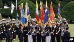 Burma's President Thein Sein, second from left, inspects an honor guard with his South Korean counterpart Lee Myung-bak, left, during a welcome ceremony at the presidential Blue House in Seoul, South Korea, October 9, 2012. 