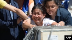 Jessica pleure à l'arrivée du cercueil de sa soeur, une domestique dont le corps a été retrouvé dans un congélateur au Koweit, Aéroport de Manille, Philippines, 16 février 2018. 