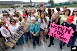 FILE - A group of women hold signs and shout their support as they wait on line to attend a Republican presidential candidate, Donald Trump campaign rally, in Wilkes-Barre, Pa., April 25, 2016.