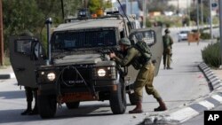 Israeli soldiers conduct a search for suspects of a shooting attack yesterday in the West Bank City of Ramallah, Dec. 10, 2018.