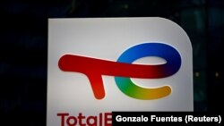 FILE: The logo of French oil and gas company TotalEnergies is pictured at an electric car charging station and petrol station at the financial and business district of La Defense in Courbevoie near Paris, France. Taken 6.22.2021