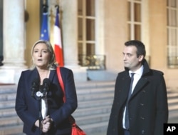 French far-right party leader Marine Le Pen , left, addresses the media with Florian Philippot after a meeting with French President Francois Hollande in Paris, Nov. 15, 2015.