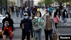 People wearing face masks are seen at a shopping area in Beijing, as the spread of the novel coronavirus disease (COVID-19) continues in the country, China April 6, 2020.