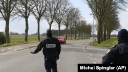 In this photo taken on March 21, 2020 police officers check on motorists in Baisieux, on the Belgian-French boarder, northern France.