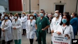 Health workers wearing face masks to protect against the spread of the coronavirus, take part in a protest at Evangelismos hospital in Athens, Nov. 12, 2020. 