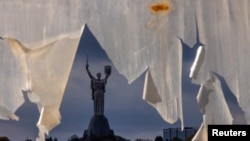 Spomenik "Otadžbina" se vidi kroz pocepano platno, Kijev, 26. oktobar, 2023. (Foto: REUTERS/Thomas Peter) 