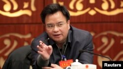 FILE - Wan Qingliang, then Communist Party Secretary of Guangzhou, gestures as he speaks at a meeting in Guangzhou, February 18, 2014.