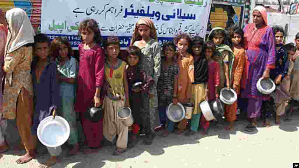 Displaced Pakistani flood-affected villagers wait for food at a distribution point in Hyderabad, Pakistan,, September 15, 2011. (AP)