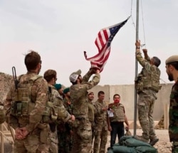 A U.S. flag is lowered as American and Afghan soldiers attend a handover ceremony from the U.S. Army to the Afghan National Army, at Camp Anthonic, in Helmand province, southern Afghanistan, May 2, 2021.