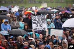 A person holds a sign that reads "Fund Climate Change Research Saving The Planet Is Not A Waste Of Money" during the March for Science in Washington, April 22, 2017.