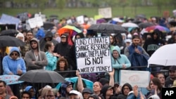 FILE - A person holds a sign that reads "Fund Climate Change Research - Saving the Planet Is Not a Waste of Money" during the March for Science in Washington, April 22, 2017.