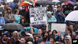 A person holds a sign that reads "Fund Climate Change Research Saving The Planet Is Not A Waste Of Money" during the March for Science in Washington, April 22, 2017.