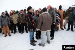 Phyllis Young, center, of the Standing Rock Sioux Tribe talks with veterans who oppose the Dakota Access oil pipeline on Backwater Bridge near Cannon Ball, N.D., Dec. 2, 2016.