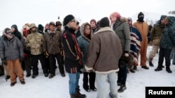 Phyllis Young (tengah) dari suku Standing Rock Sioux berbicara kepada para veteran yang mendukung aksi mereka menentang pembangunan jalur pipa di North Dakota. (Reuters/Terray Sylvester)