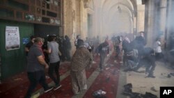 Palestinians clash with Israeli security forces at the Al Aqsa Mosque area in Jerusalem's Old City Monday, May 10, 2021. (AP Photo/Mahmoud Illean)