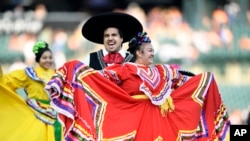 Part of a Mexican dance troupe perform on the field pregame before a baseball game between the Detroit Tigers and the Baltimore Orioles, Michigan, Sept. 14, 2024, in Detroit. The Tigers organization held many activities as part of recognizing Hispanic Heritage Month.