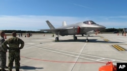 FILE - In this Sept. 19, 2019, photo, National Guard members, left, view the first two F-35 fighter jets that arrived at the Vermont Air National Guard base in South Burlington, Vt.