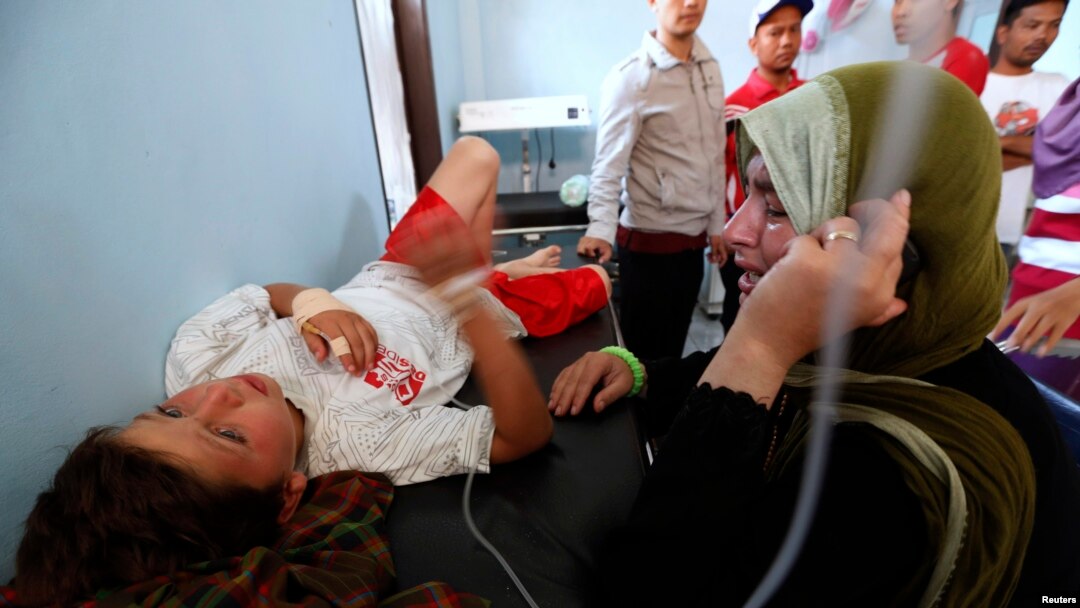 Nadine Bakour (kanan), seorang perempuan Libanon yang kehilangan suami dan dua anaknya, menangis di samping anak laki-lakinya di klinik Sukabumi, Jawa Barat (28/9).