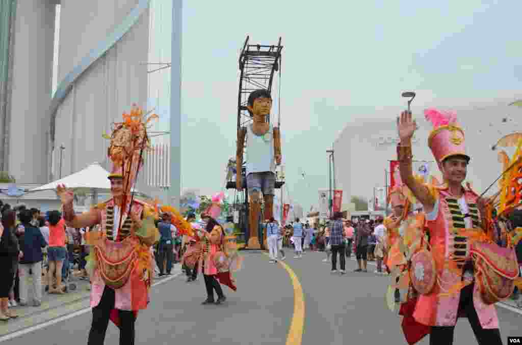 A parade with a giant marionette at the expo, Yeosu, South Korea, June 9, 2012. (S.L. Herman/VOA)