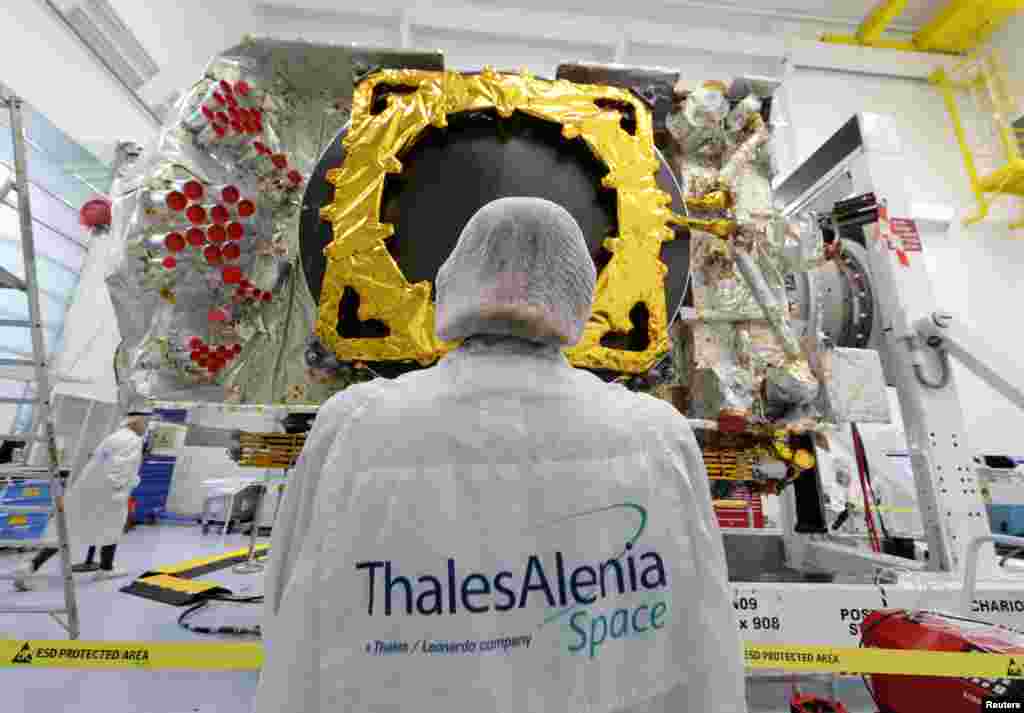 A technician stands in front of the all-electric Konnect communications satellite, which will be shipped to the Guiana Space Center in Kourou, in the clean room facilities at the Thales Alenia Space plant in Cannes, France.