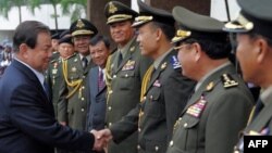 Thai Defense Minister General Yuthasak Sasiprapa, left, shakes hands with Cambodia's internal-security chief Sao Sokha, right, upon his arrival at the Ministry of Defense in Phnom Penh on Sept. 23, 2011.