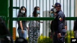 Margareth Baduel, en el centro, hija del difunto ministro de Defensa Raúl Isaías Baduel, habla con la Policía Nacional en la entrada del Cementerio Oriental en Caracas, Venezuela, el miércoles 13 de octubre de 2021.