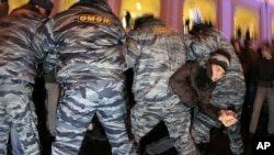 A protester tries to become free as police officers detain opposition activists during a protest against vote rigging in St.Petersburg, Russia, December 5, 2011.