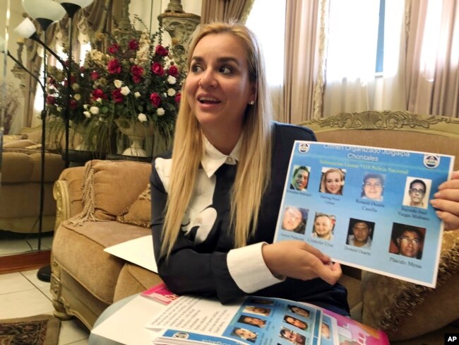 FILE - Darling Perez shows a copy of a Nicaraguan government wanted poster in which she is listed, during an interview in Miami, Oct. 15, 2018.