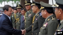 Thai Defense Minister General Yuthasak Sasiprapa, left, shakes hands with Cambodia's internal-security chief Sao Sokha, right, upon his arrival at the Ministry of Defense in Phnom Penh on Sept. 23, 2011.