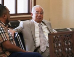 FILE - In this May 7, 2019, file photo, former Malaysian Prime Minister Najib Razak, takes a tea break at Kuala Lumpur High Court in Kuala Lumpur, Malaysia.
