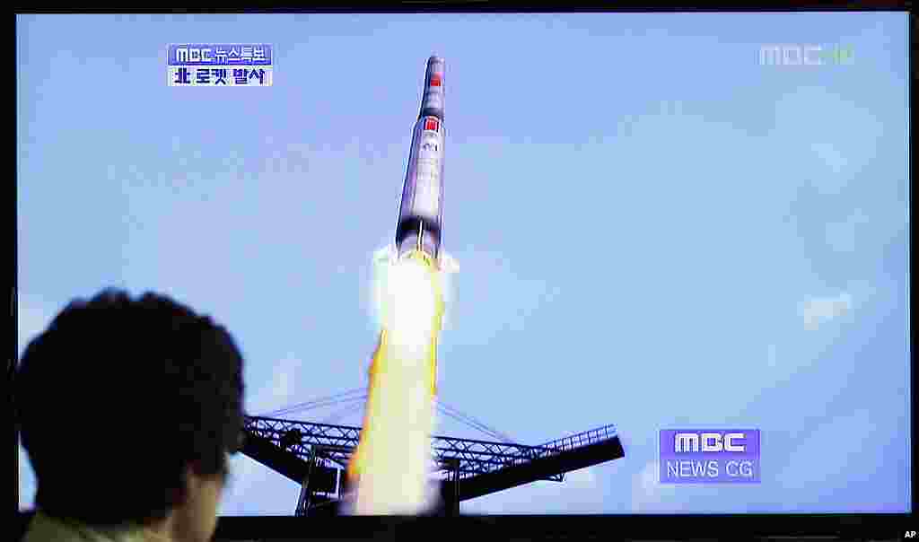 A South Korean woman watches a TV news report showing a computer generated image of North Korea's long-range rocket at Seoul train station. (AP)