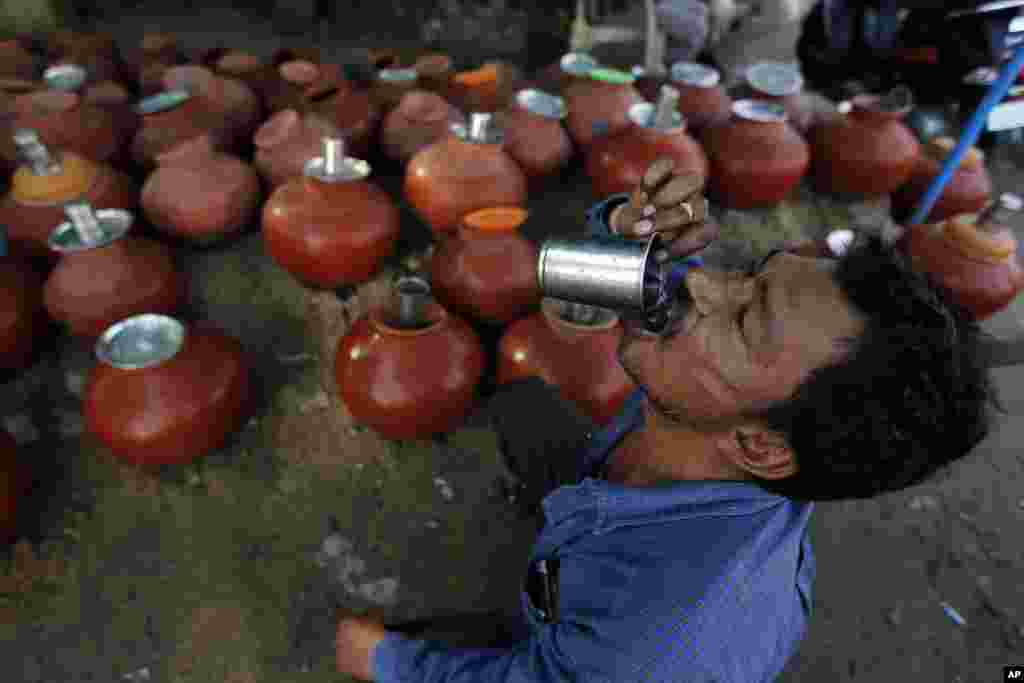 A man drinks water from an earthen pot kept by the side of a road for people on a hot day in Ahmadabad, India. Most of north India has been reeling under a heat wave with temperatures rising above 40 degrees Celsius.