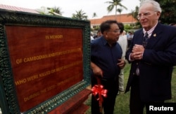 FILE - Chhang Song (L) ,former Khmer minister of information, and Carl Robinson (R), former Associated Press correspondent, stand near the sign dedicated to the memory of Cambodian and foreign journalists killed or missing during the Cambodian civil war April 22, 2010.