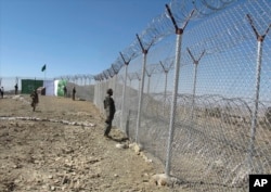 FILE - Pakistani soldiers stand guard at newly erected fence between Pakistan and Afghanistan at Angore Adda, Pakistan, Oct. 18, 2017.
