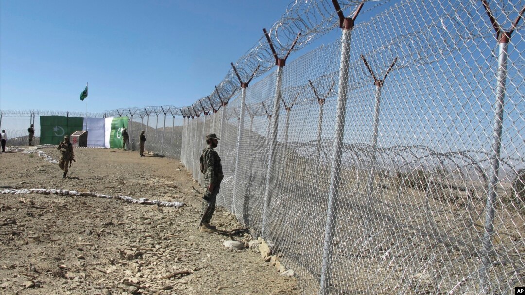 FILE - Pakistani soldiers stand guard at a newly erected fence between Pakistan and Afghanistan at Angore Adda, Pakistan, Oct. 18, 2017. 