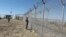 FILE - Pakistani soldiers stand guard at a newly erected fence between Pakistan and Afghanistan at Angore Adda, Pakistan, Oct. 18, 2017. 
