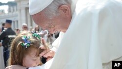 Le Pape François touche le visage de Lizzy Myers, 5 ans, de Bellville, Ohio, à la fin de l'audience générale sur la place Saint-Pierre au Vatican, le mercredi 6 Avril 2016. (L'Osservatore Romano / pool photo via AP)