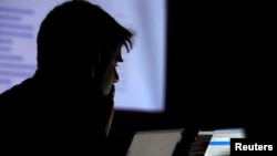 FILE - A man takes part in a hacking contest during the Def Con hacker convention in Las Vegas, Nevada.