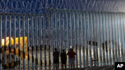 Children observe the movements of the US Border Patrol agents from the Mexican side where the border meets the Pacific Ocean, Tijuana, Mexico.