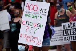 Demonstrators protest in Centennial Olympic Park, May 29, 2020, in Atlanta. Protests were organized in cities around the United States following the death of George Floyd during an arrest in Minneapolis.