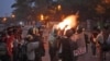 FILE - Indian police fire tear gas shells during a procession carrying the dead body of university student B. Santhosh at Osmania University in Hyderabad, India, Nov.7, 2012.