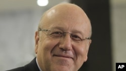 Lebanese MP and former PM Najib Mikati smiles as he delivers a news conference after meeting Lebanon's President Michel Suleiman at the presidential palace in Baabda, near Beirut, during the start of the two-day parliamentary consultations to choose a new