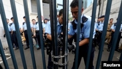Polisi mengunci gerbang ke markas polisi setelah para pengunjuk rasa mencoba menyerbu masuk, di Hong Kong, 21 Juni 2019.