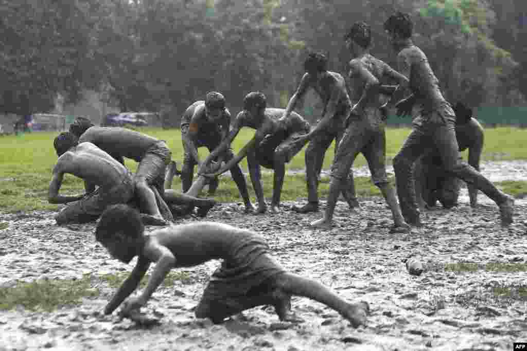 Children play a game of Kabaddi on water logged grounds in Kolkata, India.