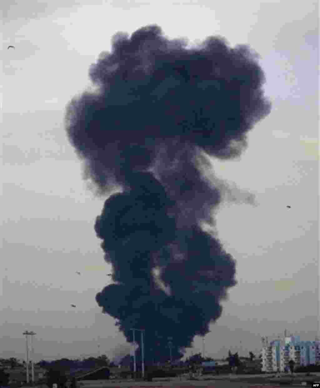 A pall of smoke billows from the point of impact after a warplane was shot down over the outskirts of Benghazi, eastern Libya, Saturday, March 19, 2011. An object, thought to be the pilot, was seen to eject from the cockpit shortly before impact. Explos