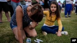 Brandy Rickaba and her daughter Emilie pray during a candlelight vigil for the slain students and teachers at Apalachee High School, in Winder, Georgia, Sept. 4, 2024.