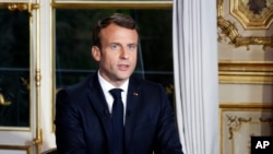 French President Emmanuel Macron sits at his desk after addressing the French nation following a massive fire at Notre Dame Cathedral, at Elysee Palace in Paris, April 16 2019.