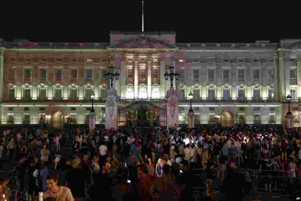 People gather outside a floodlit Buckingham Palace in London to mark the birth of a baby boy to Prince William and Kate, Duchess of Cambridge, July 22, 2013.